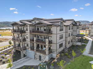 View of building exterior featuring a garage, a water and mountain view, and concrete driveway