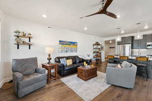 Living area featuring wood finished floors, a ceiling fan, and recessed lighting