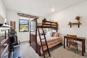 Bedroom with light colored carpet, a desk, and recessed lighting