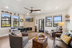 Living area featuring hardwood / wood-style flooring, a tile fireplace, a ceiling fan, and recessed lighting