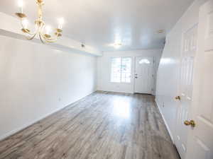 Foyer entrance featuring wood finished floors and a chandelier