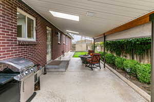 Fenced backyard featuring grilling area, a fire pit, and a shed