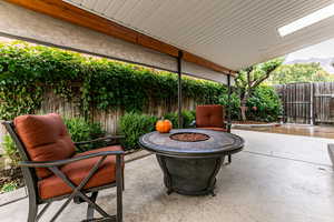 Fenced backyard with a fire pit, a patio area, and a mountain view