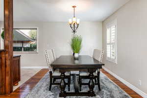 Dining area with Madrone wood flooring, plenty of natural light, and a chandelier
