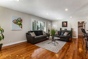 Living area featuring recessed lighting and dark wood-style flooring