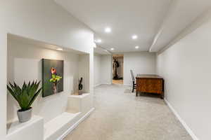 Hallway featuring light carpet and recessed lighting