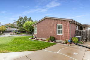 View of side of home with brick siding and a central air condition unit