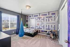 Bedroom featuring light colored carpet and wallpapered walls