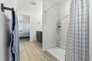 Ensuite bathroom with vanity, a shower stall, and light wood-type flooring