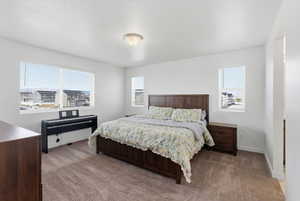 Bedroom featuring light carpet and baseboards