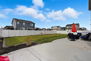 Fenced backyard featuring a patio area and a residential view