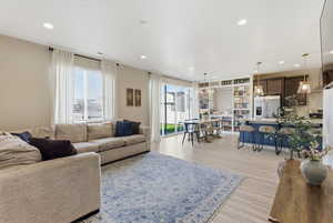 Living room with light wood-style flooring and recessed lighting