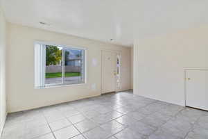 Foyer entrance featuring light tile patterned floors and baseboards