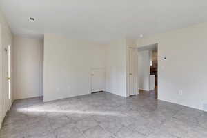 Empty room featuring baseboards and light tile patterned flooring