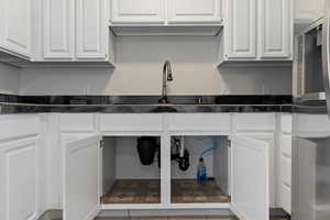 Kitchen featuring white cabinetry and freestanding refrigerator