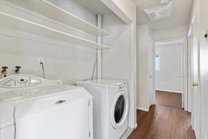 Laundry room featuring dark wood finished floors and washer and clothes dryer
