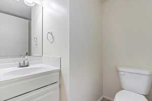 Half bathroom with vanity and toilet