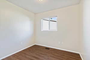 Unfurnished room with baseboards and dark wood finished floors