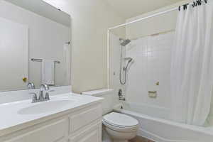 Full bathroom featuring shower / bath combination with curtain and vanity