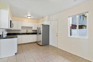 Kitchen with white cabinets, appliances with stainless steel finishes, and light tile patterned floors