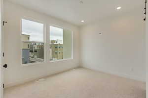Carpeted spare room featuring baseboards and recessed lighting