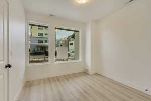 Unfurnished room featuring baseboards and light wood finished floors