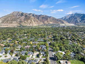 Aerial view of property and surrounding area with a mountain backdrop
