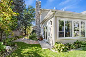 View of side of property featuring stucco siding and a chimney