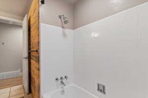 Full bath with bathtub / shower combination and light tile patterned flooring