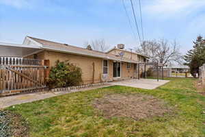 Back of house featuring brick siding, a patio area, and a gate