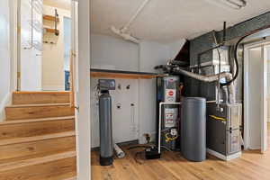 Utility room featuring heating unit and water heater