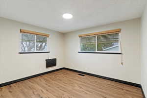 Spare room featuring a textured ceiling and light wood-style floors