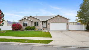 Ranch-style home featuring driveway, brick siding, a garage, and roof with shingles