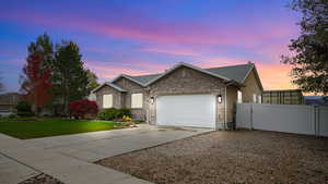Ranch-style home with driveway, a garage, a gate, and brick siding