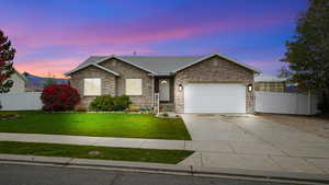 Ranch-style house featuring concrete driveway, brick siding, and a garage