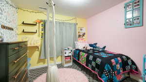Bedroom with a textured ceiling and baseboards