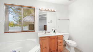 Full bath featuring a tub with jets, light tile patterned floors, and vanity