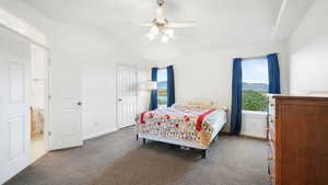 Bedroom featuring vaulted ceiling, carpet floors, and ceiling fan