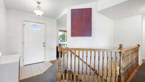 Entrance foyer with carpet and tile patterned floors