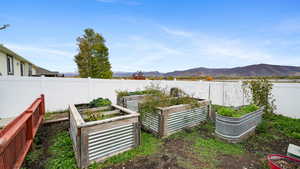 Fenced backyard with a mountain view and a garden