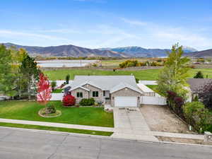 View of front of house featuring concrete driveway, a mountain view, a view of countryside, a garage, and a gate