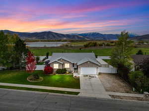 View of front of house with driveway, a mountain view, a garage, and brick siding