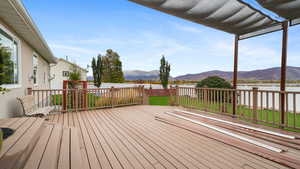 Wooden terrace featuring a mountain view and a fenced backyard