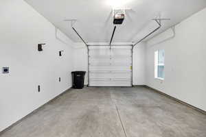 Garage with baseboards and a garage door opener