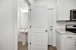 Bathroom with dark wood-style flooring and baseboards