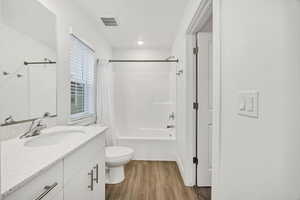 Bathroom with shower / tub combo, vanity, and light wood-style flooring