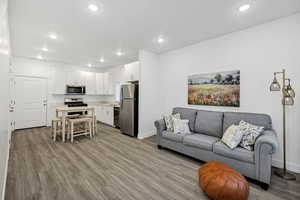 Living room with light wood-style floors and recessed lighting