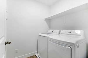 Washroom featuring baseboards and washing machine and clothes dryer