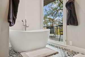 Full bathroom featuring a freestanding tub and tile patterned flooring