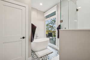 Bathroom featuring a soaking tub, a shower stall, tile patterned floors, and recessed lighting